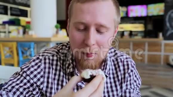 一个留着胡子的年轻人正在吃蛋糕视频的预览图
