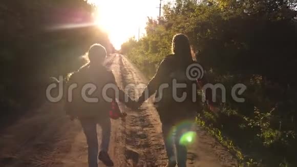 少女旅行牵手儿童旅行者徒步旅行者女孩带背包的快乐女孩旅行者沿着乡村奔跑视频的预览图