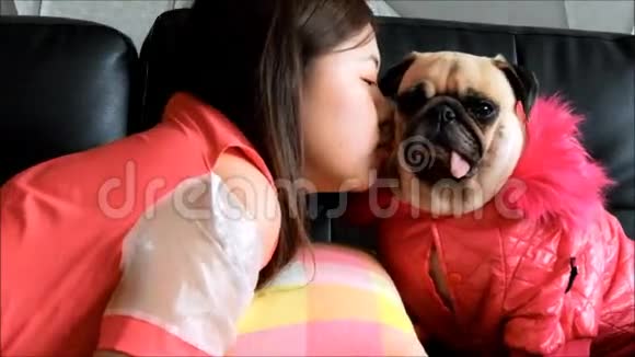 年轻的亚洲美女在沙发上对着她的小狗吹吻视频的预览图