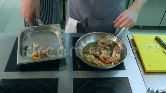 厨师把煎虾从锅中取出放到一个特别的盘子里视频的预览图