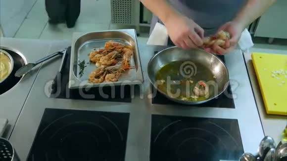 厨师男的手把虾仁放在蒜蓉煎锅上视频的预览图