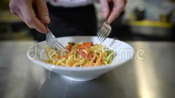 厨师在餐厅的厨房里煮番茄酱在框架中手拿叉子给盘子带来美视频的预览图