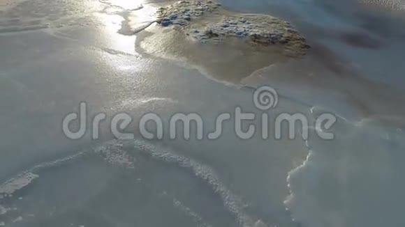 相机在冰面上移动表面覆盖着冰雪太阳光线照在冰上寒冷的冬天视频的预览图