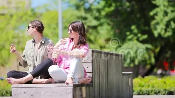 快乐的年轻城市女孩在公园户外听音乐白种人游客一起在户外玩视频的预览图