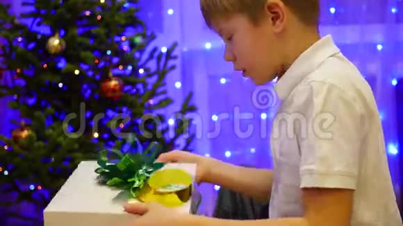 圣诞礼物惊喜一个孩子打开礼物背景中bokeh灯和花环视频的预览图