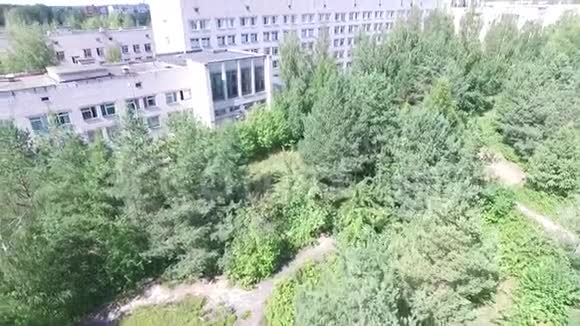 从空中俯瞰小镇建筑物和树木的空中测量飞过院子飞过人们头视频的预览图