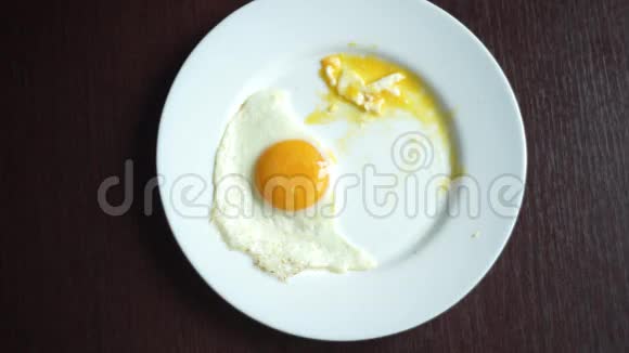 手拿刀叉在盘子里吃煎蛋的俯视图视频的预览图