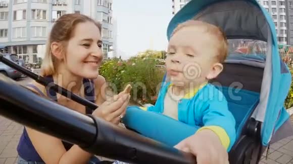可爱的宝贝儿子坐在婴儿车里吃饼干视频的预览图