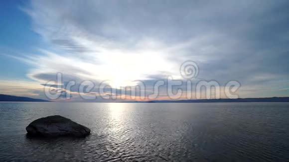 黎明时分水中的石头和乌云视频的预览图