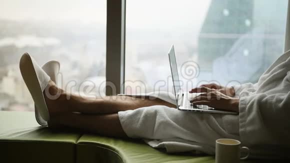 商务人员在家工作或旅行坐在床上使用的年轻英俊商人的侧景画像视频的预览图