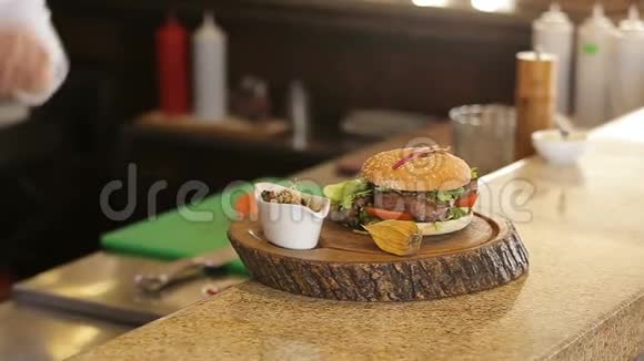 木制餐盘上加酱的熟食汉堡视频的预览图