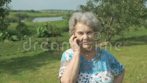 80岁的老年妇女在户外交流手机视频的预览图
