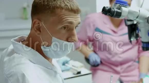 在医院接受病人时戴口罩的牙科助手视频的预览图