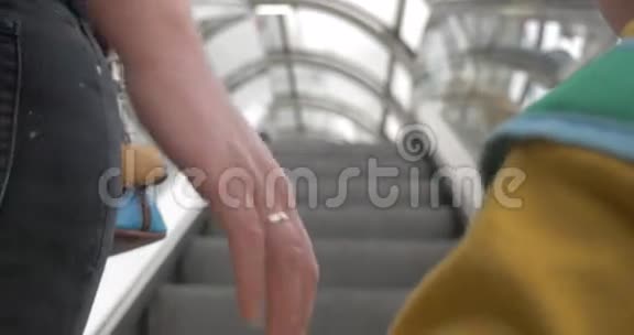 母亲和儿子在乘坐自动扶梯时牵手视频的预览图