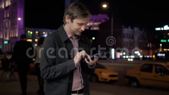 年轻人在户外使用现代智能手机男人在社交网络上和朋友聊天散步视频的预览图