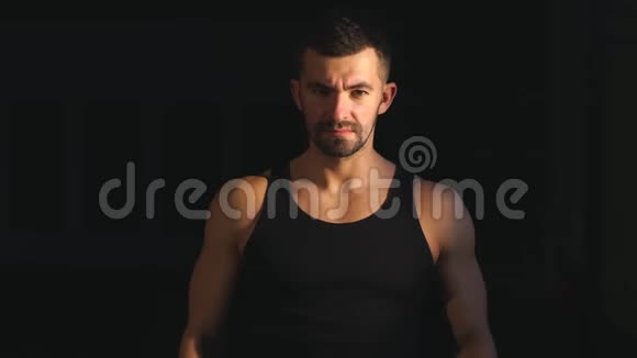 强壮的肌肉胡须健美运动员在用哑铃训练前用粉笔粉拍手视频的预览图