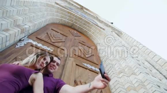 年轻人和漂亮女孩在大漂亮门的背景上自拍视频的预览图