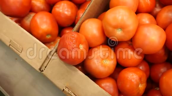 一个女人在蔬菜货架上的超市里买蔬菜和水果男人从腐烂的蔬菜中选择西红柿视频的预览图