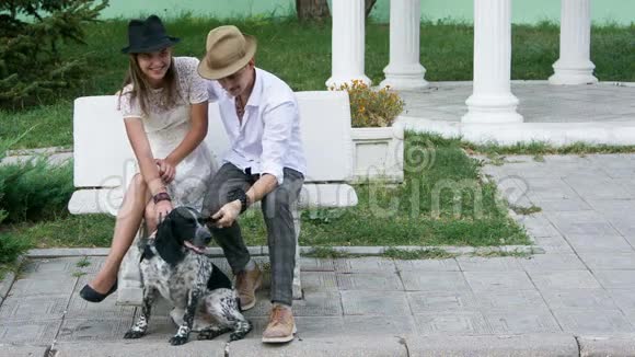 戴帽子的男人和女人抚摸狗视频的预览图
