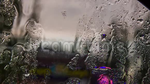 雨中汽车挡风玻璃上的水滴和水流视频的预览图