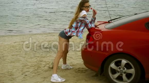 红唇美女在海滨舔棒棒糖视频的预览图