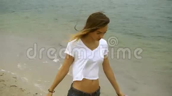 迷人的少女在海滩上散步视频的预览图