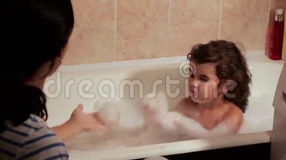 美丽的卷发女孩沉溺于泡沫浴和他妈妈一起泡澡视频的预览图