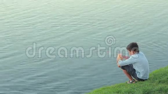 小男孩在池塘里钓鱼喂鱼视频的预览图