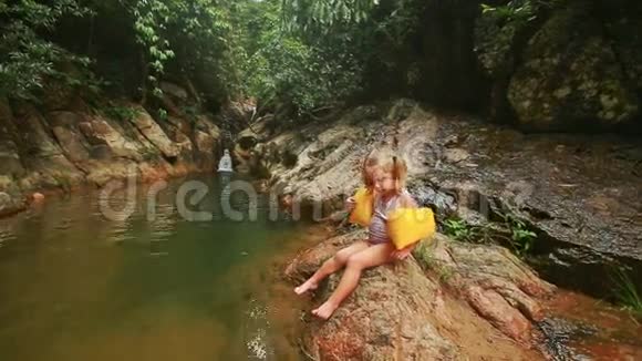 在河边的石壁上的小女孩视频的预览图