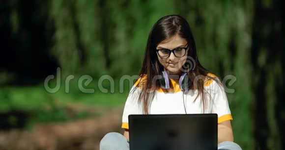 在公园里用笔记本电脑工作的女人视频的预览图