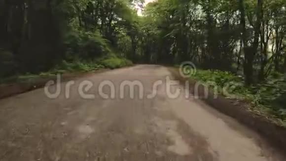 在森林里的柏油路上奔跑是第一人称视角镜头有节奏地摇摆POV屏幕保护程序视频的预览图