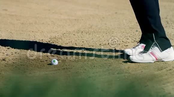 一名女子高尔夫球手在沙滩高尔夫球场被击中白色高尔夫球朝视频的预览图