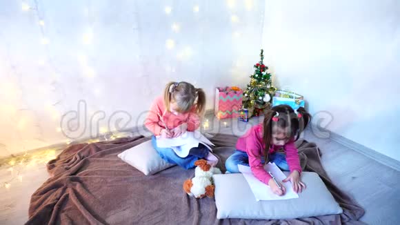 小女孩笑着说话摆姿势躺在地板上枕头靠墙里面放着花环和圣诞树视频的预览图