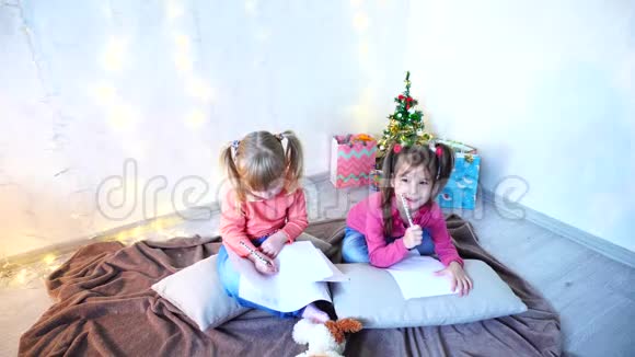 有趣的小女孩笑着说话摆姿势躺在地板上枕头靠墙戴着花环和圣诞树视频的预览图