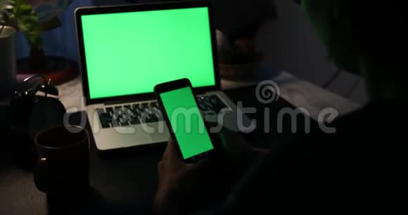 使用智能手机和带有绿色屏幕的笔记本电脑多利在视频的预览图