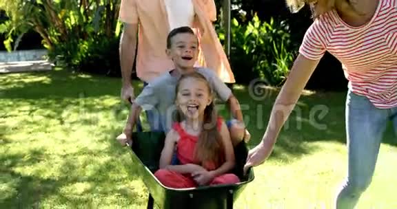 花园里玩手推车的可爱家庭的画像视频的预览图
