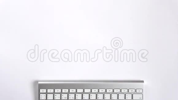 白色办公桌上的键盘鼠标平板电脑耳机文具笔记本视频的预览图