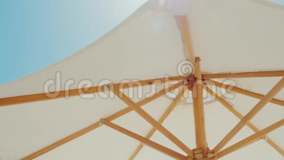 白色的雨伞顶着蓝天度假胜地的海滩度假Stedicam射击视频的预览图