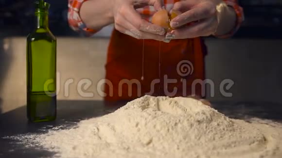 厨师把鸡蛋扔在一堆面粉上在披萨店的厨房里视频的预览图