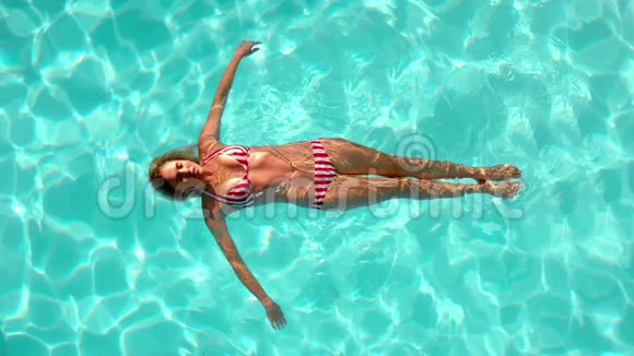 在游泳池里漂浮着电影摄影的女人视频的预览图