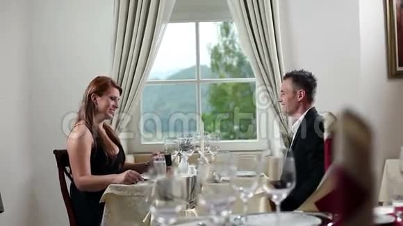 年轻夫妇在漂亮的餐厅里吃浪漫午餐带高档盘子视频的预览图