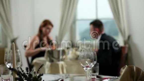 一对年轻夫妇在吃晚饭侍者点着蜡烛浪漫视频的预览图