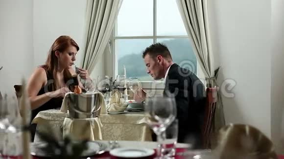 一对年轻夫妇趁着白光在高级餐厅吃庆祝晚餐视频的预览图