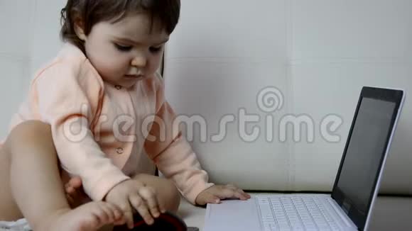 可爱的宝宝白色毯子背景上有笔记本电脑视频的预览图