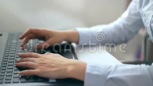 在白色办公室里女性用手在笔记本电脑键盘上打字视频的预览图
