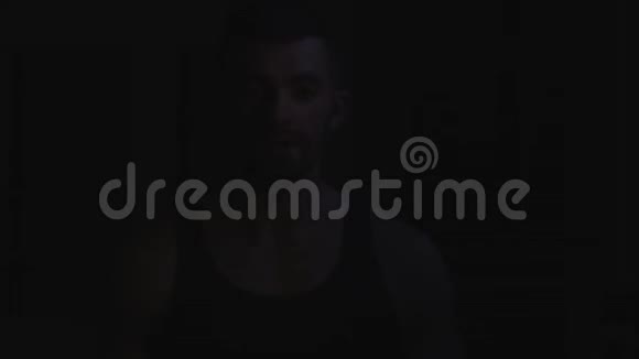 强壮的肌肉胡须健美运动员在用哑铃训练前用粉笔粉拍手视频的预览图