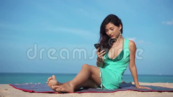旅行女孩在海滩上的电话中使用应用程序视频的预览图