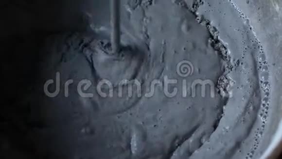 工人用一桶水泥把松散的材料和水混合成水泥视频的预览图