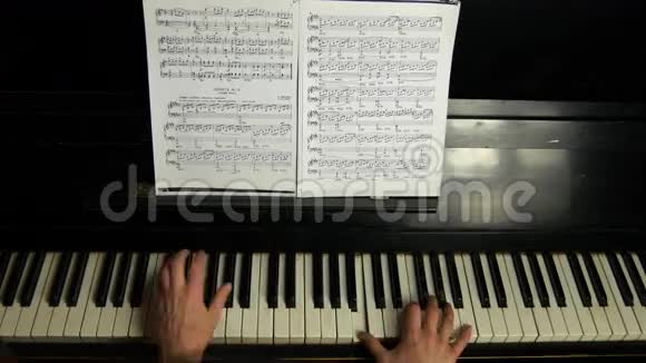 顶部的女性手在一架漂亮的大钢琴上演奏一首轻柔的古典音乐弹钢琴的女人视频的预览图