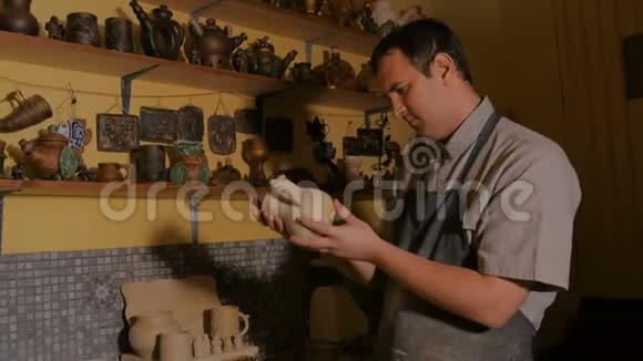 专业男性陶工在制陶车间检查壶视频的预览图